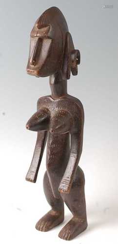 * An ancestor figure, carved as a nude female in standing po...