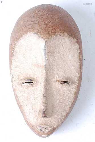 * A carved wooden mask with applied koalin to the face, Lega...