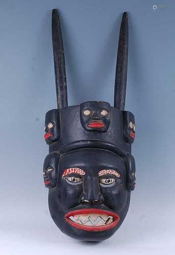 A large African ritual mask, having two horns with polychrom...