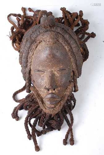 * A carved wooden dance mask, having original braided plant ...