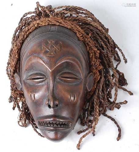 * A carved wooden initiation mask, having braided plant fibr...