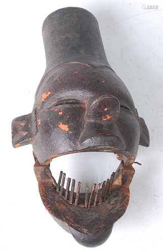 * A carved initiation mask, having a hinged jaw, with overla...