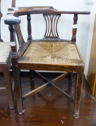 A mid 18th century oak rush seat corner elbow chair