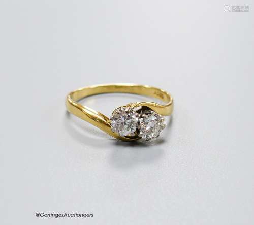 An 18ct and two stone diamond set crossover ring, size O, gr...