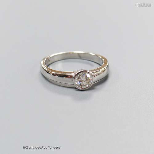 A modern platinum and collet set solitaire diamond set ring,...