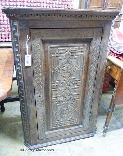 A carved oak hanging corner cupboard, width 70cm, depth 42cm...