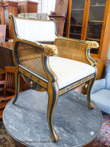 A parcel gilt ebonised elbow chair in the manner of Thomas H...