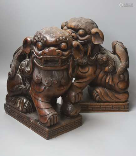 A pair of Chinese carved hardwood Buddhist lions, width 26cm...