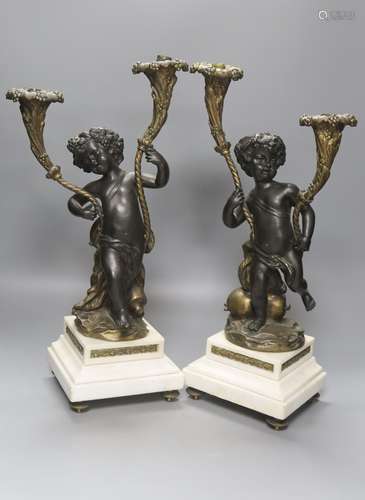 After Clodion. A pair of bronze cherub candelabra on marble ...