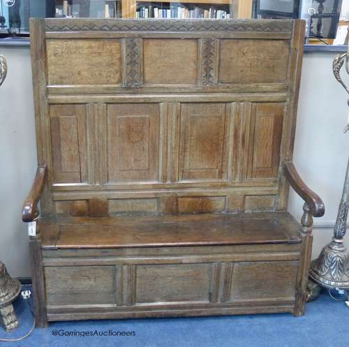 A 17th century panelled oak settle, with later seat, length ...