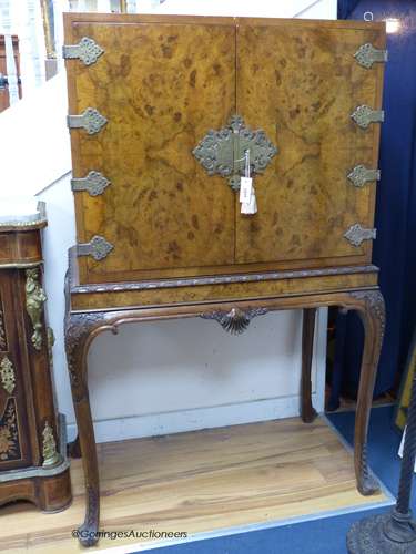 A Queen Anne style carved burr walnut cocktail cabinet on st...