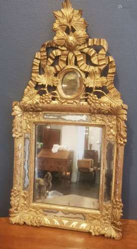 Miroir à pareclose en bois sculpté doré surmonté d'un fronto...