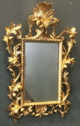 ITALIE. Miroir en bois sculpté, doré à décor feuillagé dans ...