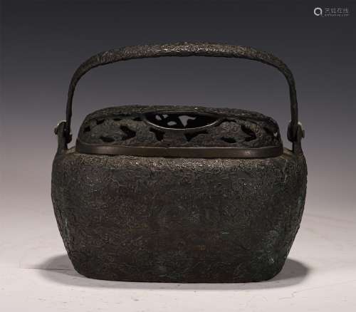 A CARVED BRONZE HANDWARMER WITH LOOP HANDLE