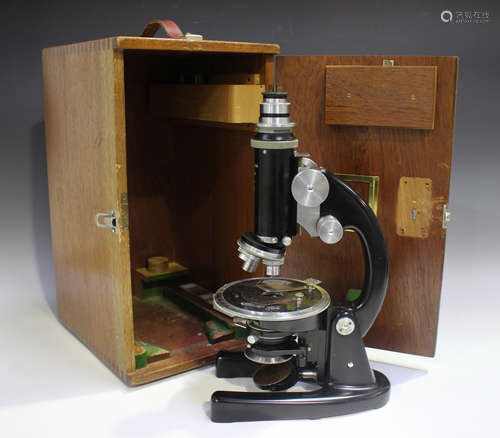 A mid-20th century black enamelled monocular microscope, sig...