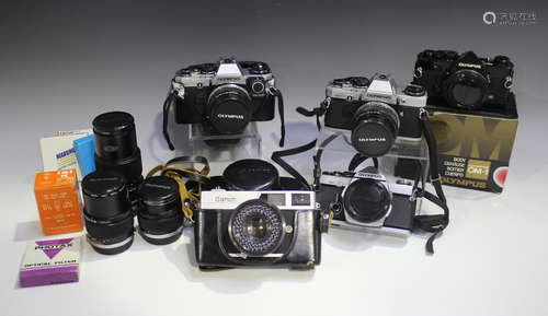 A collection of Olympus cameras and lenses, comprising OM-2 ...