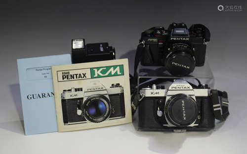 A Pentax KM camera with Pentax-M 1:2.8 35mm lens, together w...