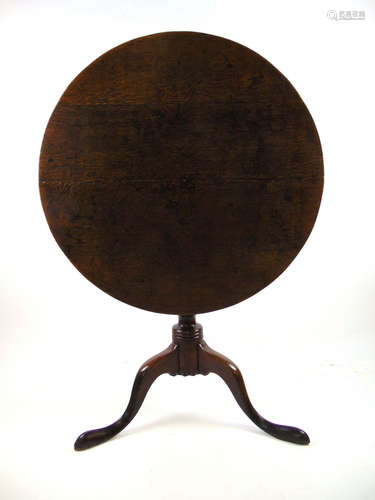 An 18th century oak tilt top tripod table, the circular top ...