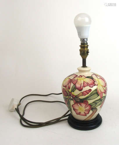 A Moorcroft lamp base with decorated in a purple, yellow and...