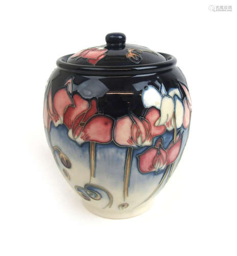 A Moorcroft 'Wild Cyclamen' pot and cover decorated on a blu...