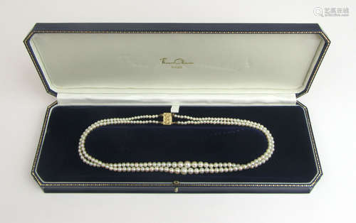 A double stand cultured pearl necklace having a yellow metal...