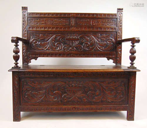 A late Victorian carved oak box settle,