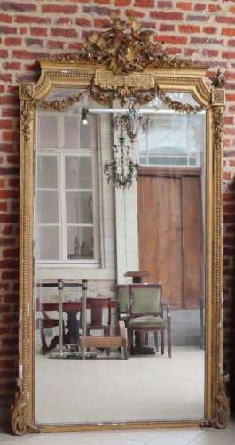 Important miroir en bois et stuc doré, le fronton à décor de...