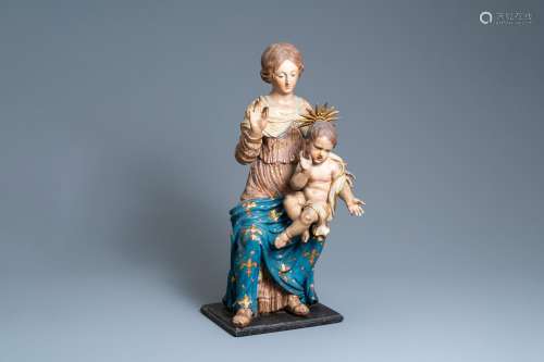 Une grande statue d'une Vierge à l’enfant en bois sculpté et...