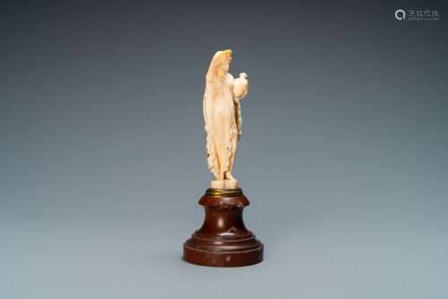 Une statue d'une jeune femme en ivoire sculpté vêtue d’un dr...