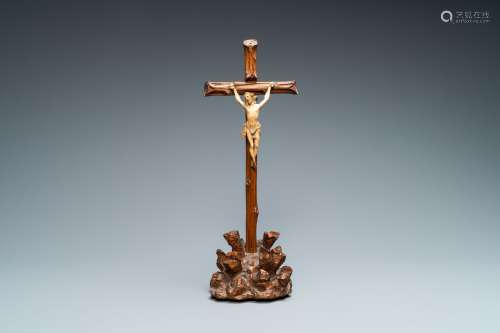Un crucifix avec Christ en ivoire sur une croix en bois en f...