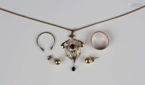 A gold and garnet two stone pendant in a scroll pierced open...