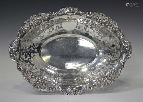 An Edwardian silver oval dish, the outswept scalloped rim de...