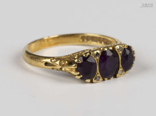 An 18ct gold ring, mounted with three oval cut amethysts and...