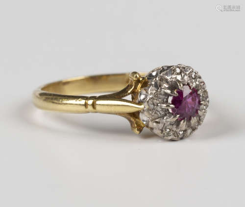 An 18ct gold, ruby and diamond cluster ring, claw set with a...