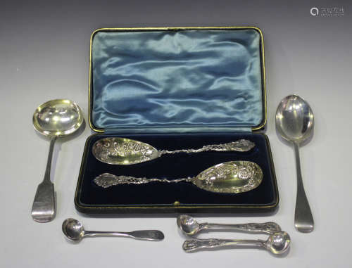 A near pair of Edwardian silver berry spoons, each ovoid bow...