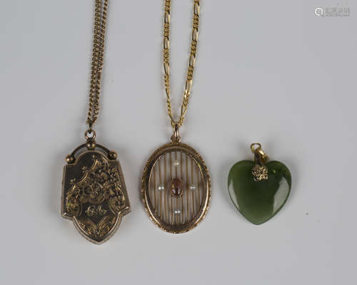 A gold pendant locket with scroll and foliate engraved decor...