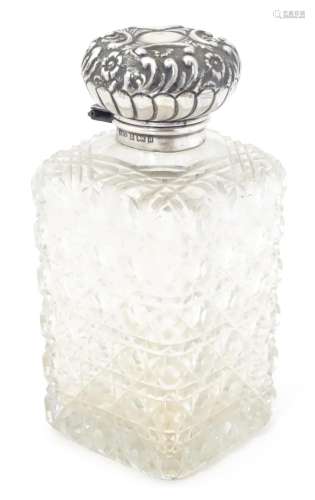 A cut glass scent bottle of square form with silver top