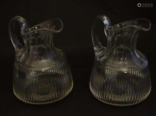 A pair of late 19thC glass jugs, decorated with etched
