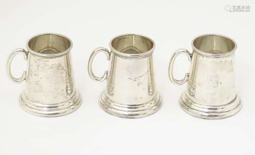 A set of three sterling silver miniature tankards /