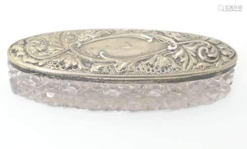 A cut glass dressing table pot with silver lid.