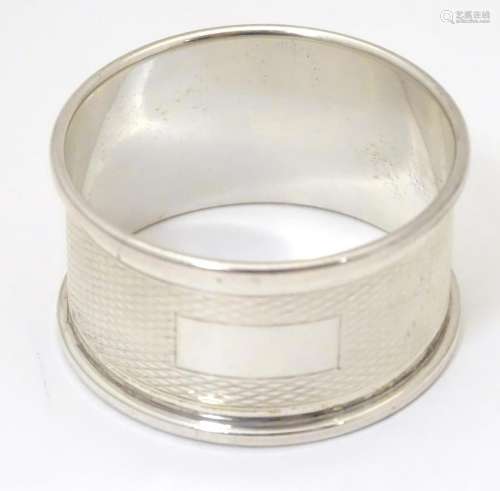 A silver napkin ring with engine turned decoration,