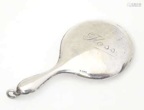 A silver compact formed as a miniature hand mirror,