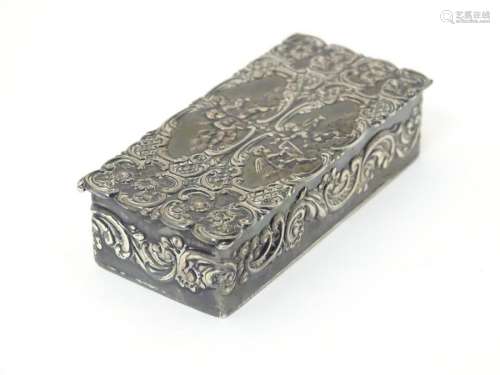 A embossed silver box with a hinged lid opening to