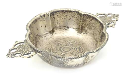 A silver quaich with twin handles and embossed rose