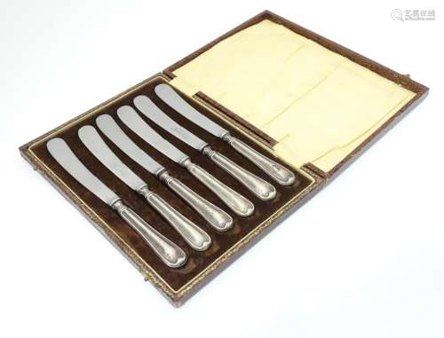 A cased set of six silver handled butter knives.