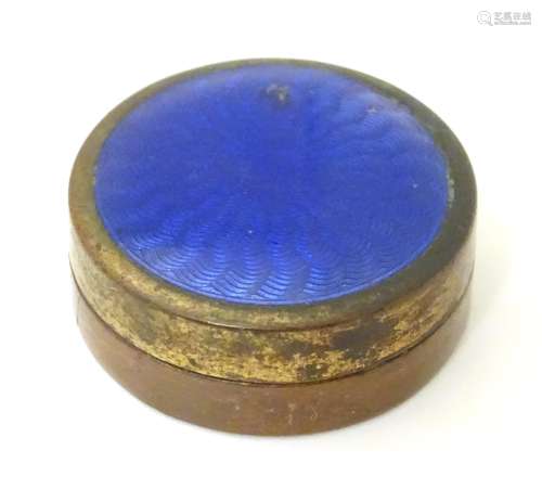 A gilt metal pill box with guilloche enamel decoration