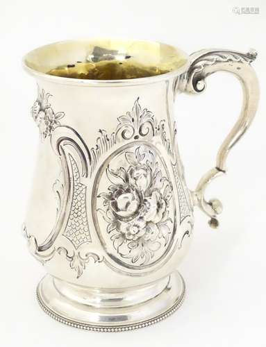 A Victorian silver mug with embossed decoration and