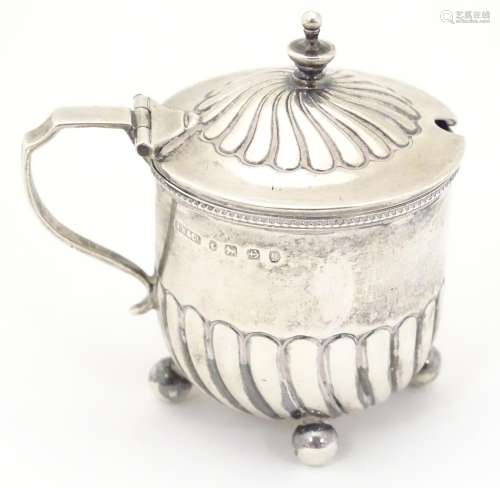 A Victorian silver mustard pot with fluted detail and