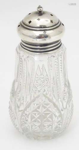 A cut glass sugar shaker / caster with a silver lid,