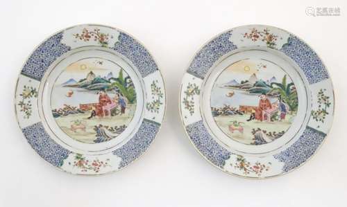 A pair of Chinese plates depicting a two figures in a